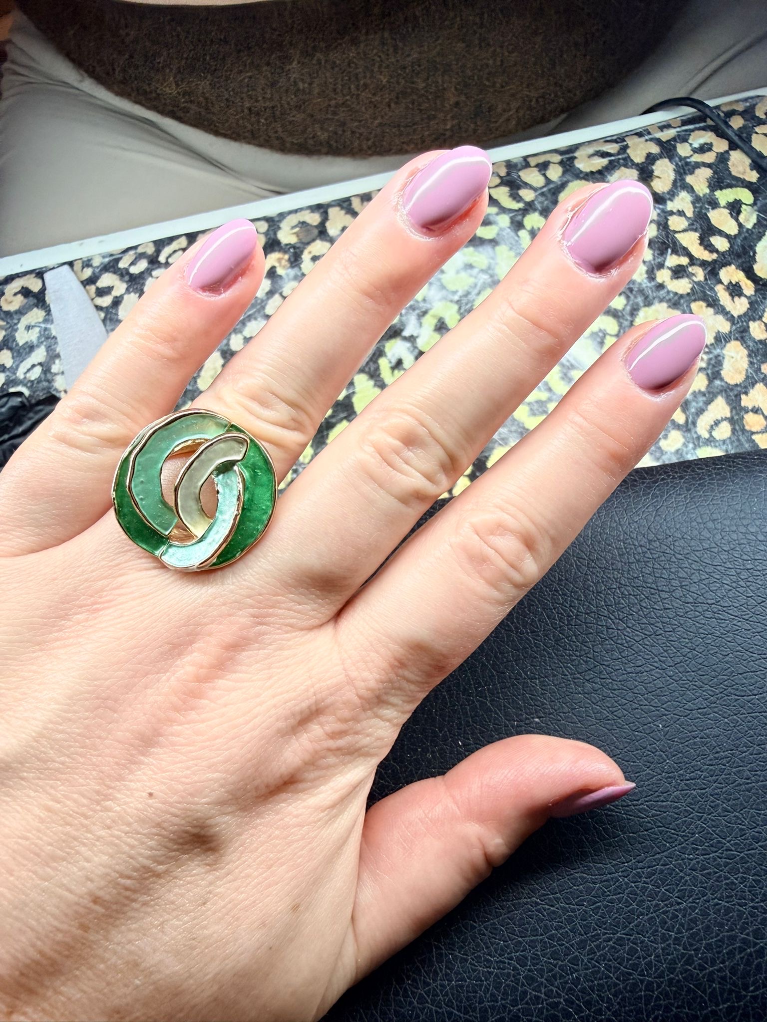 Lila gelnagels en een groene statement ring